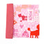 coperta arrotolata in tessuto rosa con barboncini